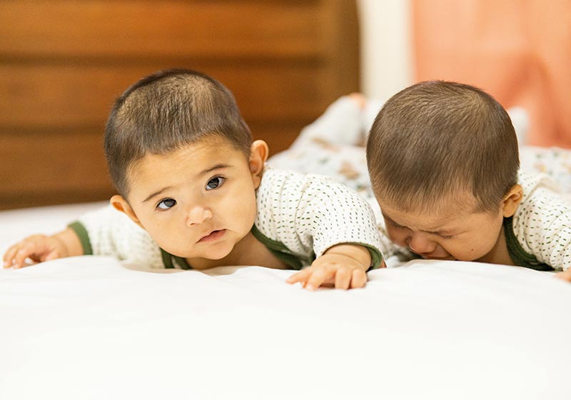 Genitori che aiutano il neonato ipotonico a migliorare con esercizi di fisioterapia.